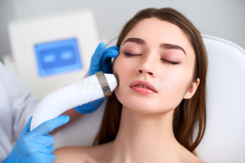 Beautician ud?wigu doktorska robi procedura dla doskona?ej kobiety twarzy k?a?? w pi?kno salonie Narz?dzia kosmetologia zdjęcie royalty free Beautician ud?wigu doktorska robi procedura dla doskona?ej kobiety twarzy k?a?? w pi?kno salonie Narz?dzia kosmetologia zdjęcie royalty free