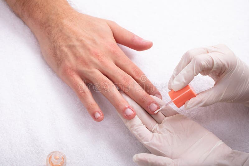 Beautician που εφαρμόζει το πετρέλαιο καρφιών σε ετοιμότητα ανθρώπινο στοκ φωτογραφίες Beautician που εφαρμόζει το πετρέλαιο καρφιών σε ετοιμότητα ανθρώπινο στοκ φωτογραφίες