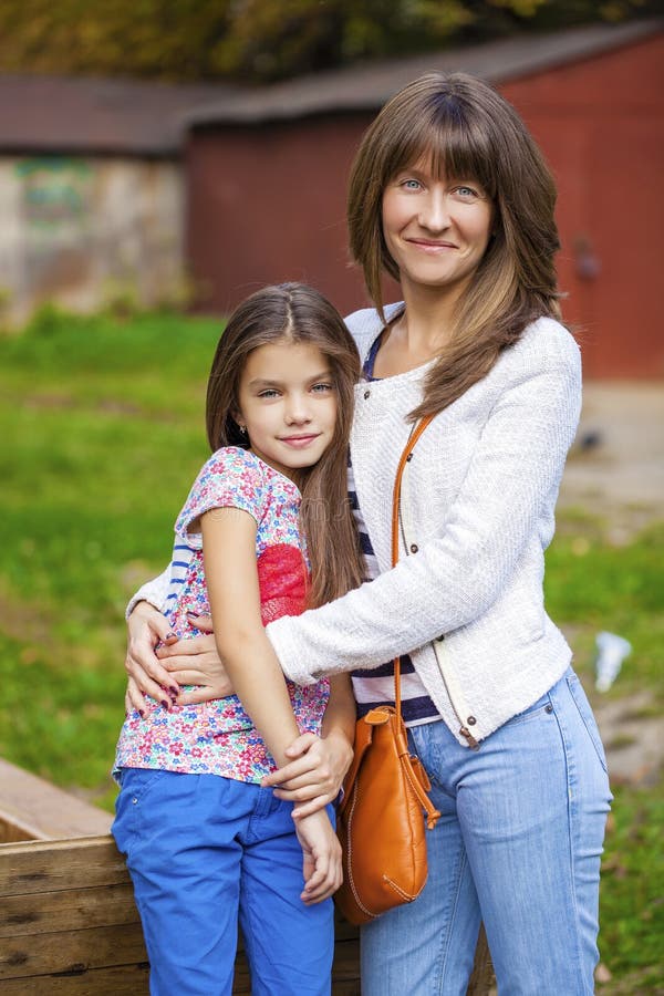 Beautifal little girl and happy mother in the autumn park