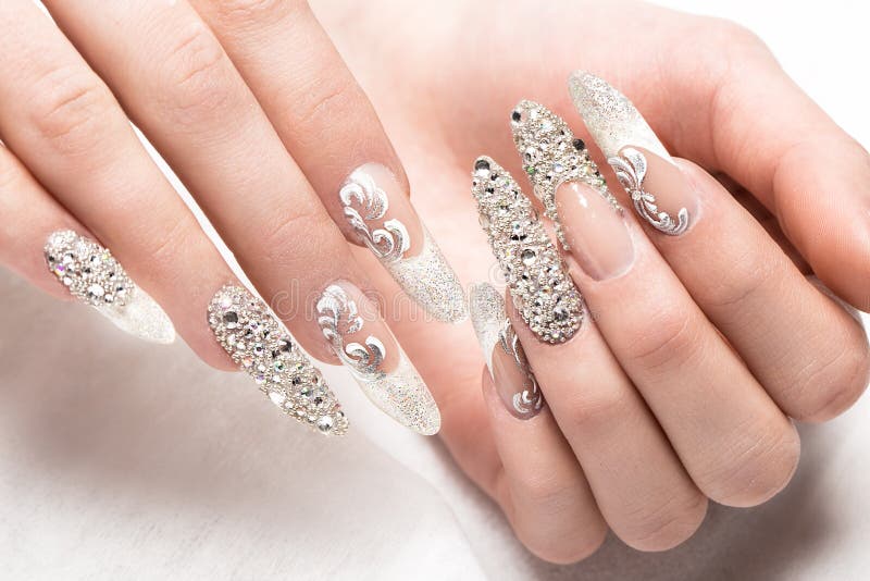 Beautifil-Hochzeitsmaniküre für die Braut in den leichten Tönen mit Bergkristall Nageldesign Nahaufnahme stockfoto Beautifil-Hochzeitsmaniküre für die Braut in den leichten Tönen mit Bergkristall Nageldesign Nahaufnahme stockfoto