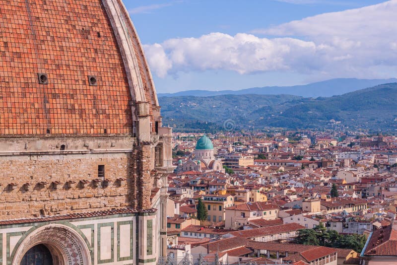 Beautifu view of city skyline, towers, basilicas, red-tiled roofs of houses and mountains, Florence, Italy