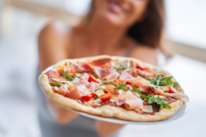 Beautiful adult woman eating pizza at home