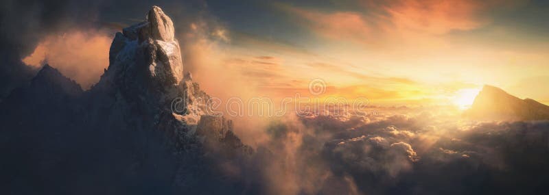 Beautiful aerial landscape of mountain peak at sunset above the clouds - panoramic. Photo