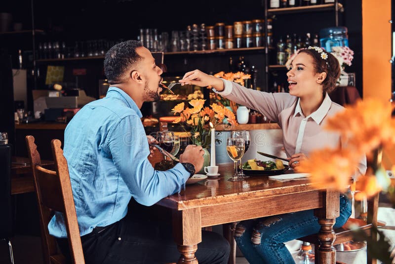 Beautiful African-American couple in love having a great time together at their dating, an attractive couple enjoying