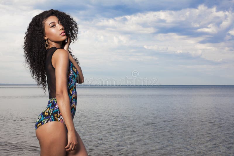 Young beautiful African American girl relaxing at the beach.