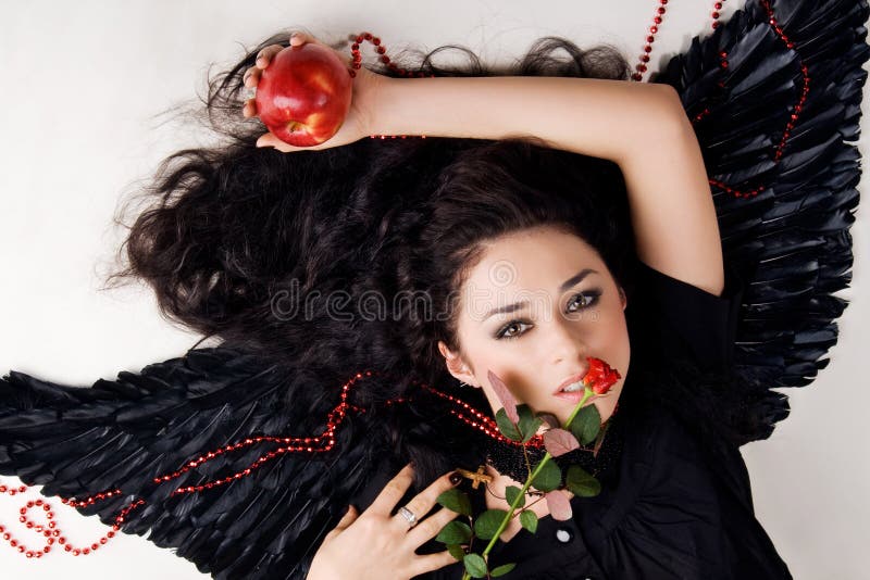 Beautiful angel with a red apple and rose