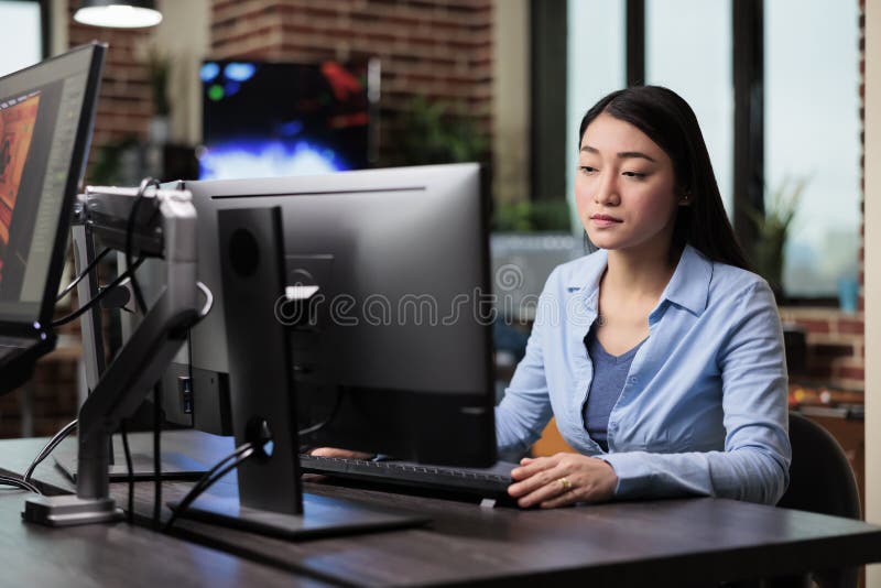 Beautiful asian creative artist sitting at desk while developing digital art royalty free stock images