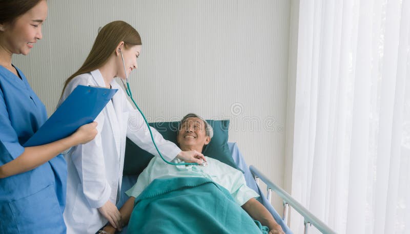 Beautiful Asian doctor listens to heart patient in hospital bed. stock photography Beautiful Asian doctor listens to heart patient in hospital bed. stock photography