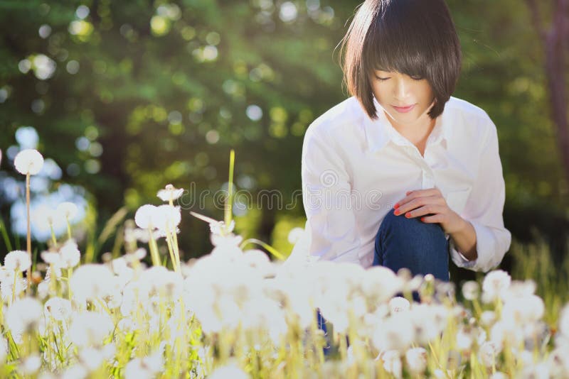 Beautiful asian girl in dandelion flower field