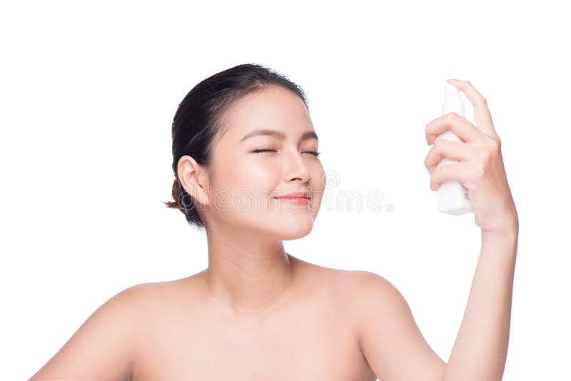 Beautiful asian woman applying spray water on face whit