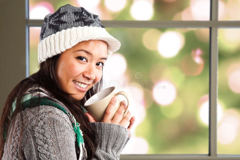 A shot of a happy beautiful asian woman drinking coffee