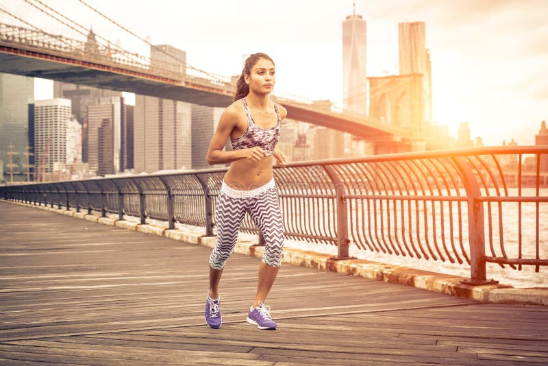 Beautiful asian woman running in New york at sunset time.