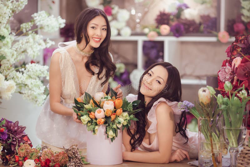 Beautiful asian women florists with bouquet of flowers in flower store