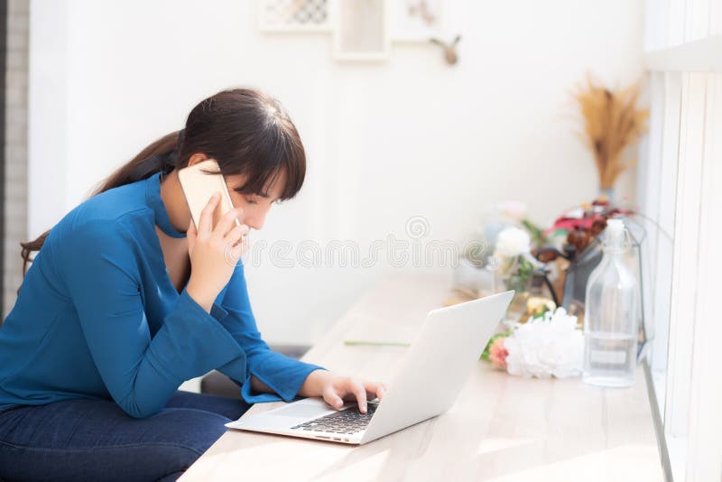 Beautiful asian young businesswoman excited and glad of success work with laptop, girl taking mobile smart phone royalty free stock photo Beautiful asian young businesswoman excited and glad of success work with laptop, girl taking mobile smart phone royalty free stock photo
