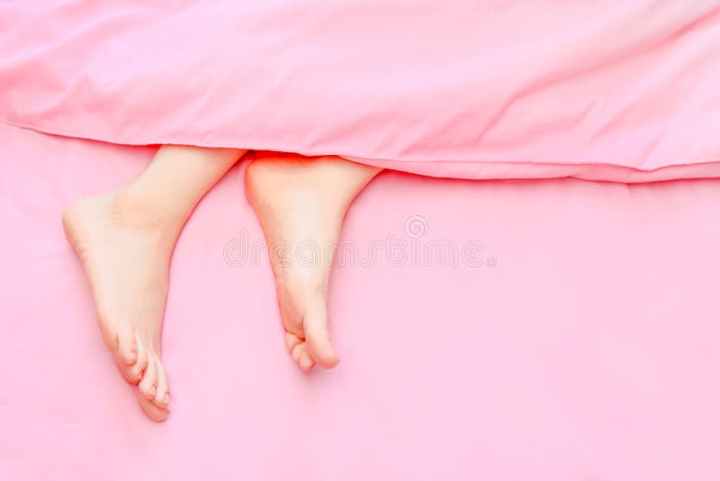 Beautiful Asian Young Woman Body Legs and Feet on The Pastel Pink Bedroom Background. Female Foot in Bed Sleep Relax. royalty free stock photos Beautiful Asian Young Woman Body Legs and Feet on The Pastel Pink Bedroom Background. Female Foot in Bed Sleep Relax. royalty free stock photos
