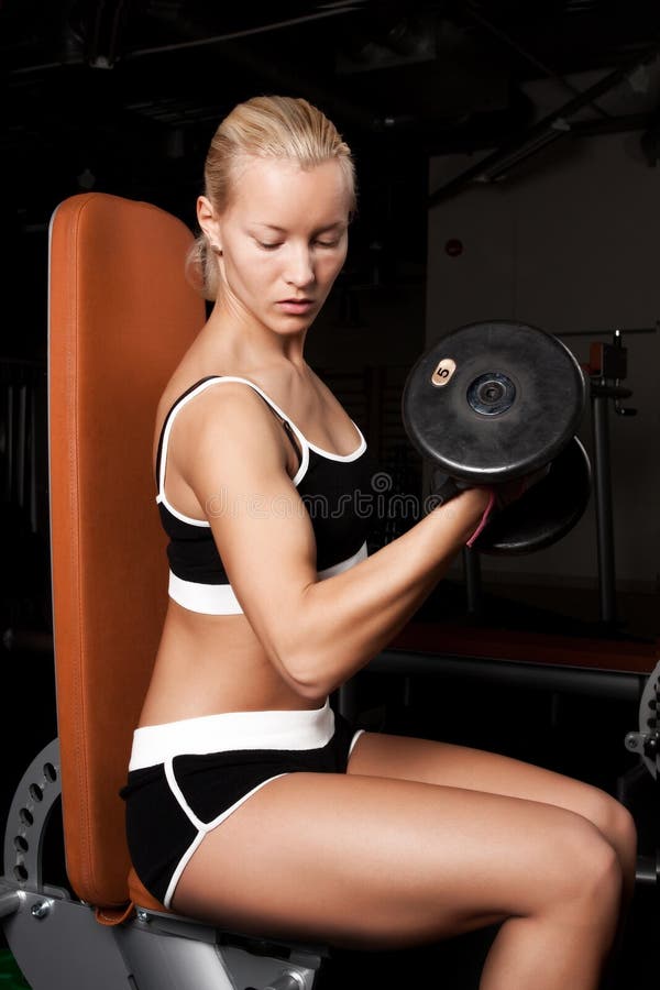 Beautiful athlete lifting heavy weights