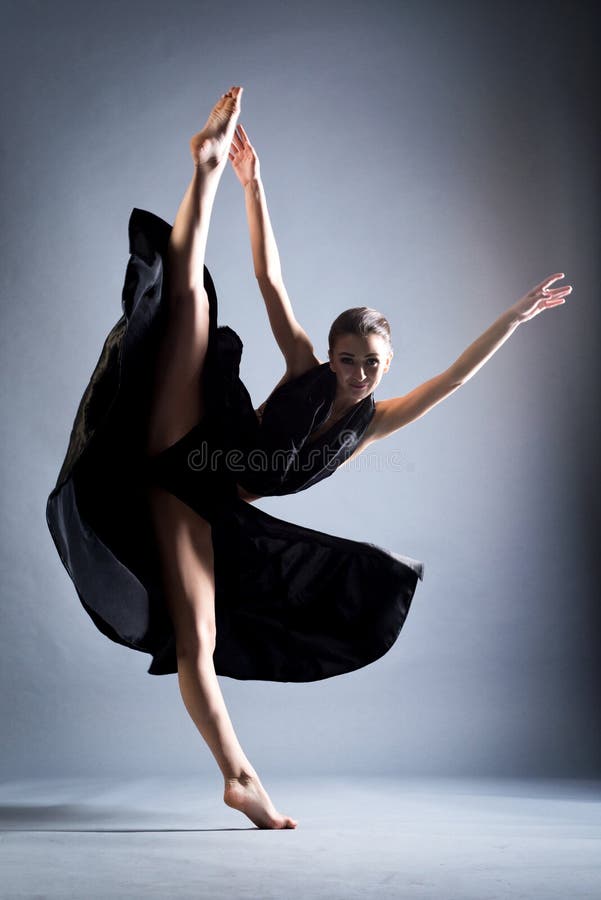 A Beautiful Athletic Girl in a Black Dress is Dancing. in Move Stock ...