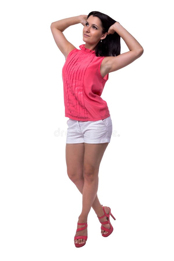 Beautiful, attractive young woman in blouse and short shorts smiles sweetly, raising his hands hair, full length royalty free stock photography Beautiful, attractive young woman in blouse and short shorts smiles sweetly, raising his hands hair, full length royalty free stock photography