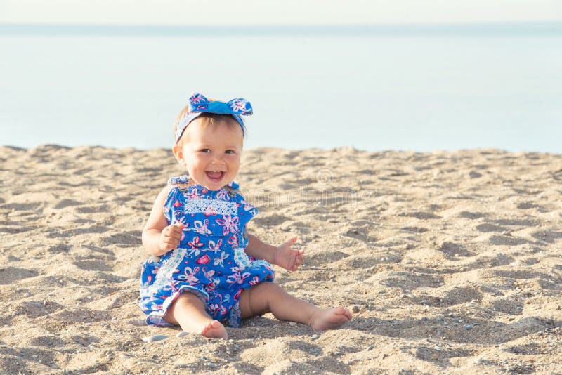 Beautiful baby girl playing on the sand by the sea royalty free stock photos Beautiful baby girl playing on the sand by the sea royalty free stock photos