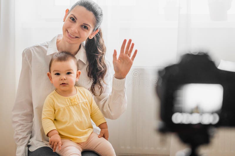Beautiful baby toddler with young mother in front of the camera vlogging or blogging indoors royalty free stock photo Beautiful baby toddler with young mother in front of the camera vlogging or blogging indoors royalty free stock photo