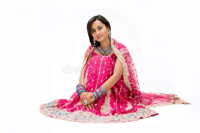 Beautiful Bangali bride in colorful dress sitting, isolated