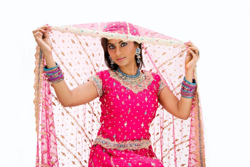 Beautiful Bangali bride in colorful dress and lifting her veil, isolated