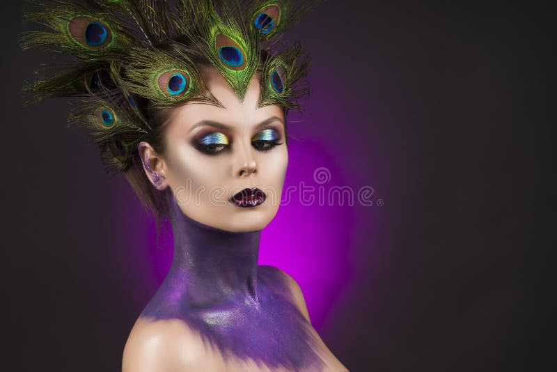 Beautiful big breast girl wearing peacock feathers in her hair a royalty free stock photos Beautiful big breast girl wearing peacock feathers in her hair a royalty free stock photos