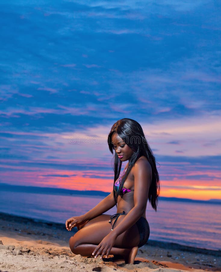 Portrait of beautiful black African American woman posing on the beach at sunset