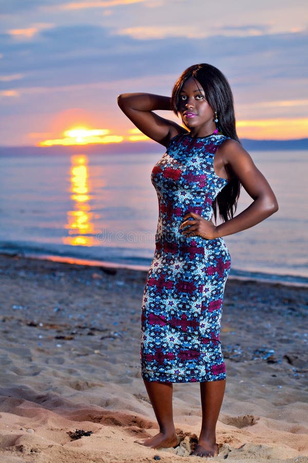 Beautiful black African American woman posing on the beach at sunset