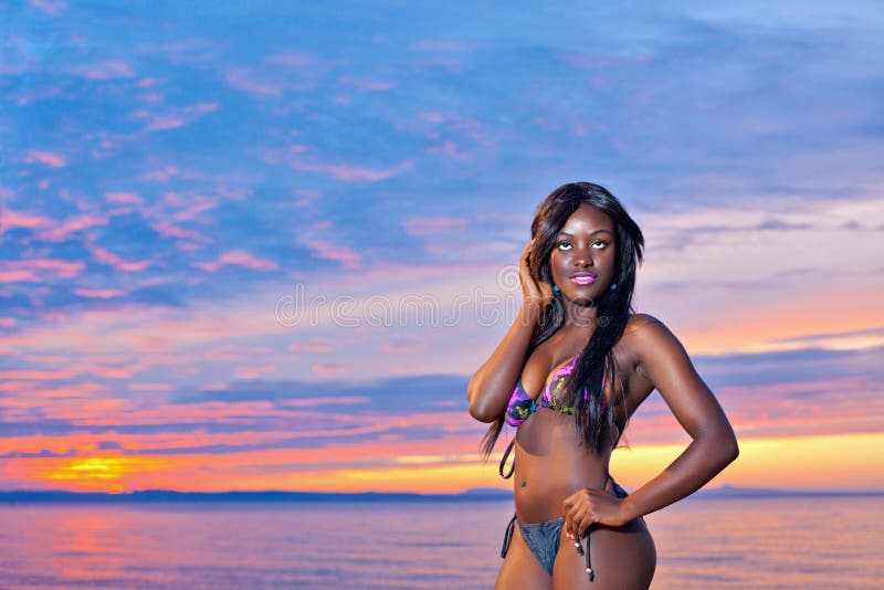 Beautiful black African American woman posing on the beach at sunset