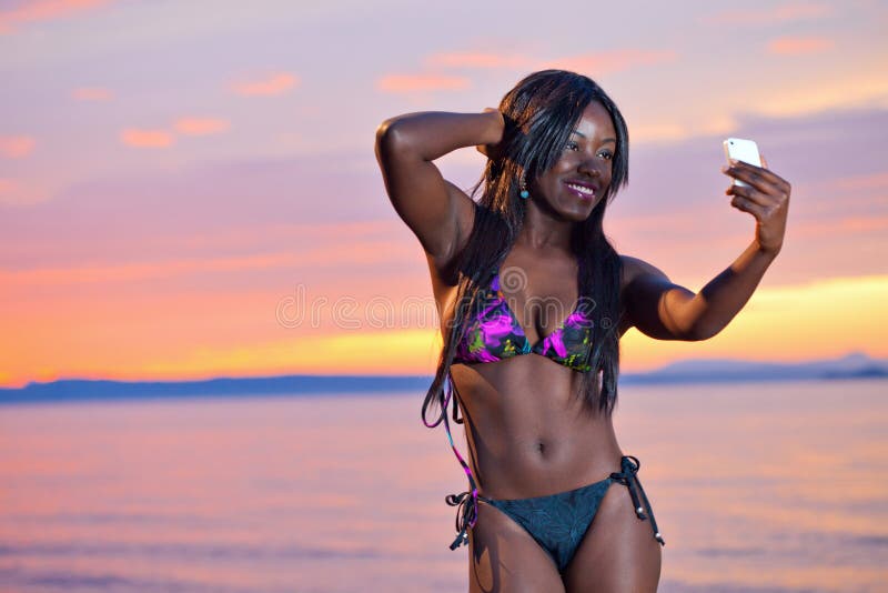 Beautiful black African American woman posing on the beach at sunset