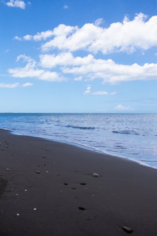 Beautiful black sand beach and ocean at shoreline