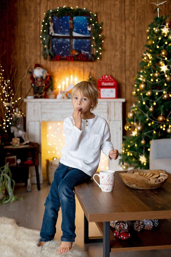 Beautiful blond child, young school boy, playing in a decorated home with knitted toys