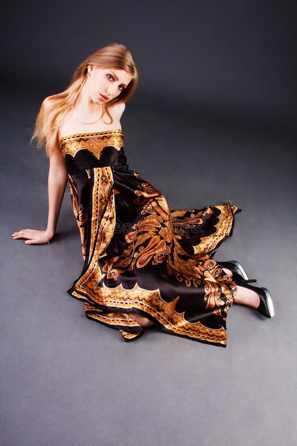 Beautiful blond girl in dress on floor