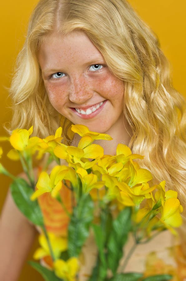 Beautiful blond girl with freckles holding a bouquet of flowers