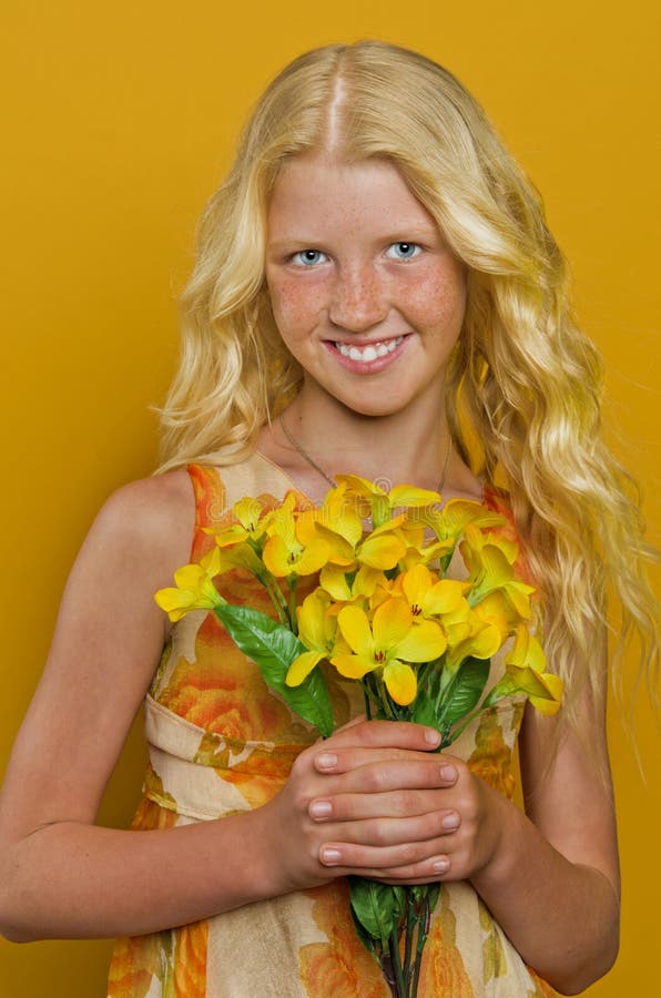 Beautiful blond girl with freckles holding a bouquet of flowers