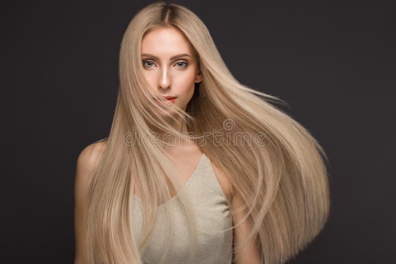 Beautiful blond girl in move with a perfectly smooth hair, and classic make-up. Beauty face. stock image Beautiful blond girl in move with a perfectly smooth hair, and classic make-up. Beauty face. stock image