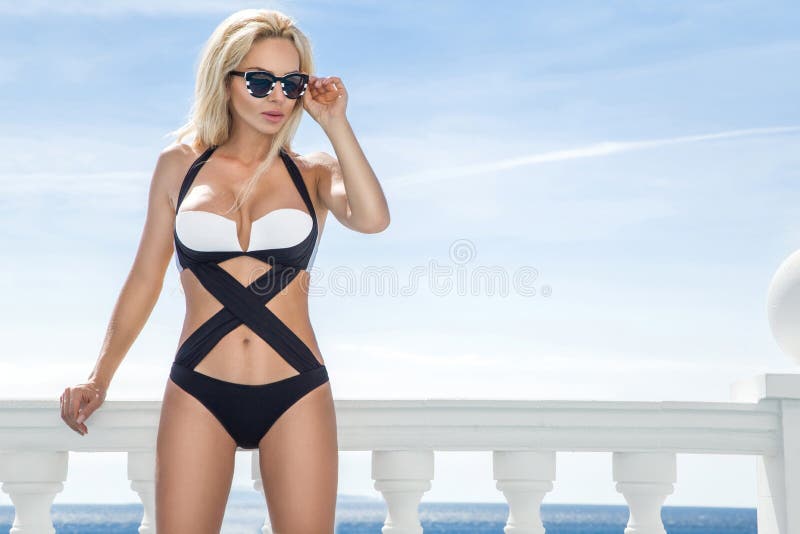 Beautiful blond hair woman young girl model in sunglasses and elegant white and black swimsuit royalty free stock image Beautiful blond hair woman young girl model in sunglasses and elegant white and black swimsuit royalty free stock image