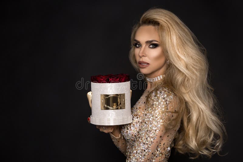 Beautiful blond model in elegant dress holding a gift, flower box with roses. Valentine`s gift royalty free stock photo Beautiful blond model in elegant dress holding a gift, flower box with roses. Valentine`s gift royalty free stock photo