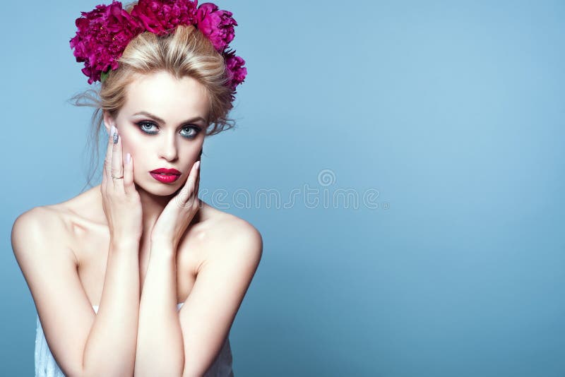 Beautiful blond model with updo hair blown by the wind and perfect make up wearing peony head garland stock images Beautiful blond model with updo hair blown by the wind and perfect make up wearing peony head garland stock images