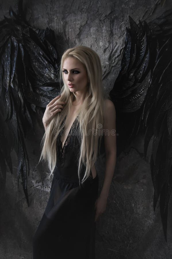 Beautiful blond woman in black dress with black wings