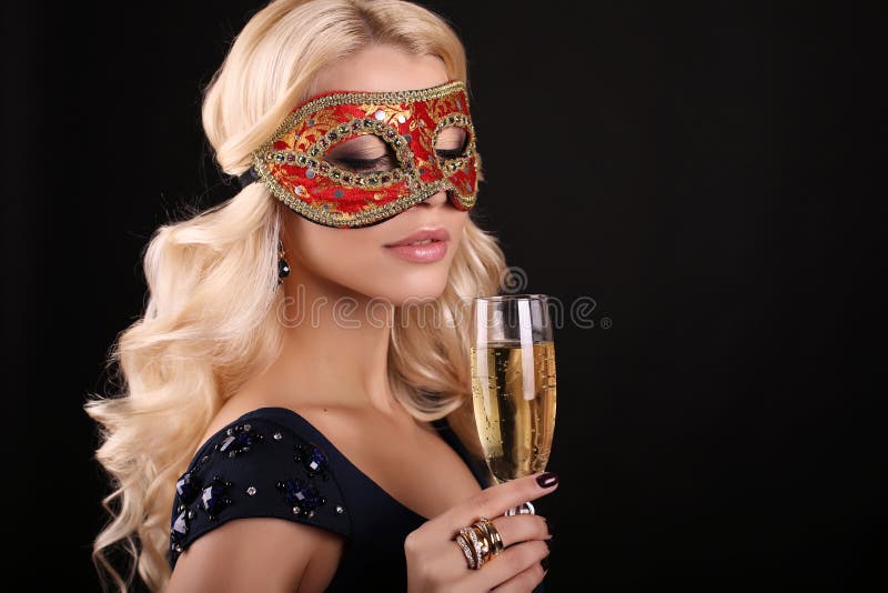 Beautiful blond woman in carnival mask,with glass of champagne