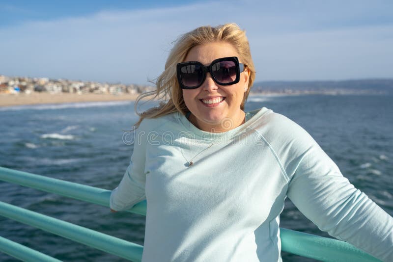 Beautiful blond woman poses on the Manhattan Beach California pier in the late afternoon sunshine stock photography Beautiful blond woman poses on the Manhattan Beach California pier in the late afternoon sunshine stock photography