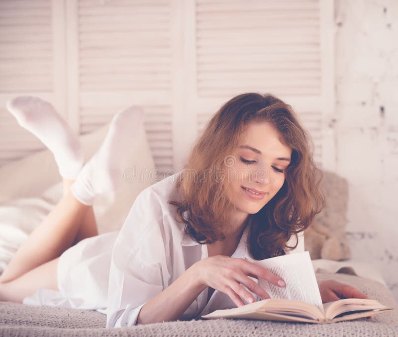 beautiful blond woman reading book in the bed. Relaxing concept