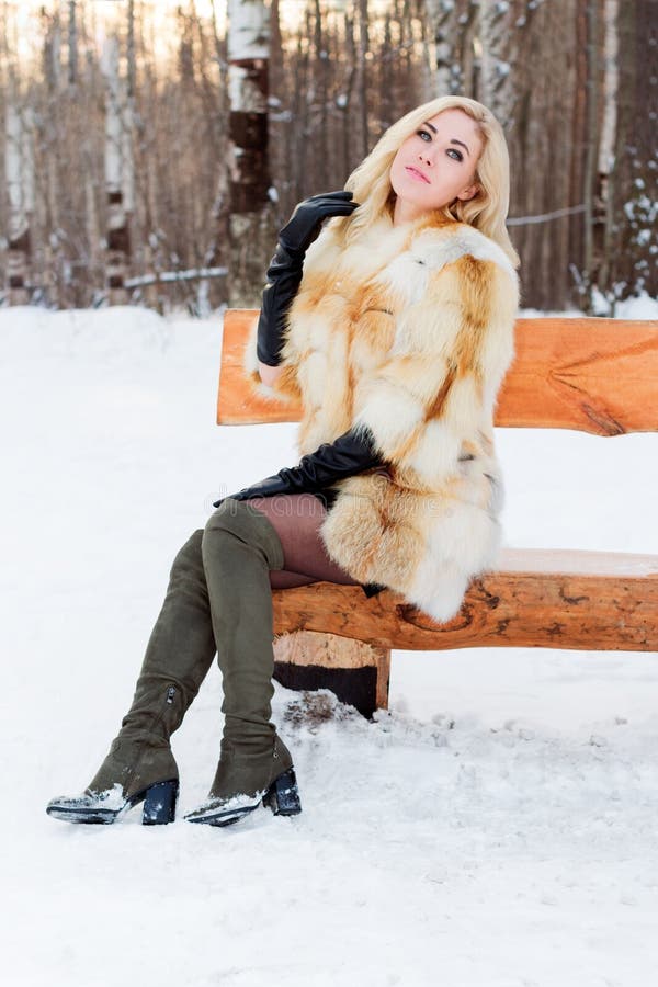 Beautiful Blonde in Fur Coat, Boots Poses on Wooden Bench Stock Image ...