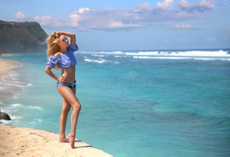 Girl in the jeans shorts posing on Melasti beach royalty free stock photography Girl in the jeans shorts posing on Melasti beach royalty free stock photography
