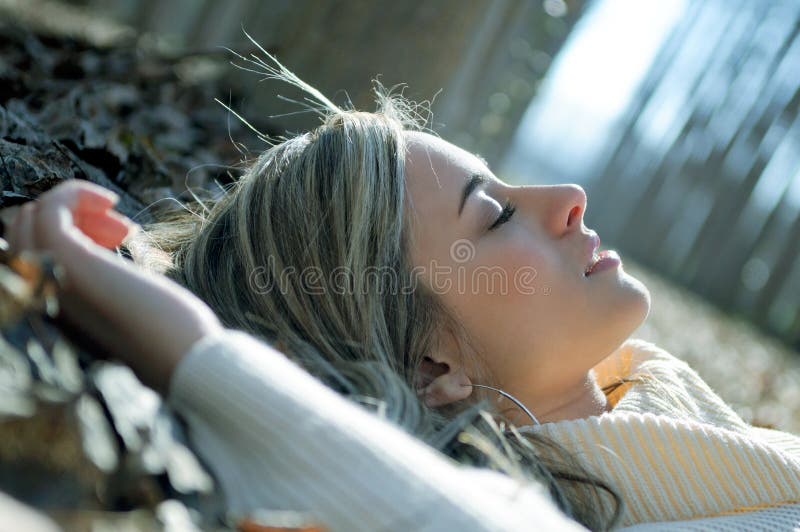 Beautiful blonde girl lying on leaves