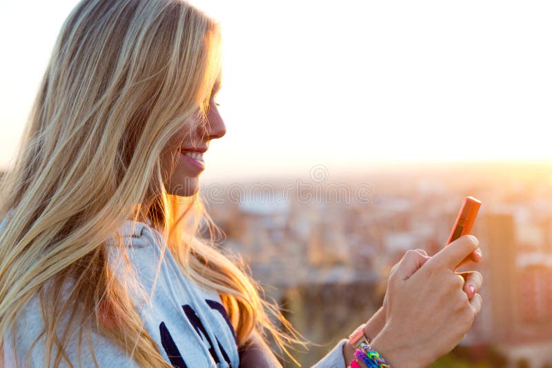 Beautiful blonde girl taking pictures of the city.