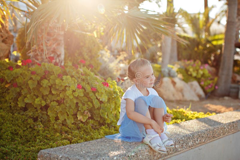 Beautiful blonde girl 5 years old in a blue skirt smiling on the stock image Beautiful blonde girl 5 years old in a blue skirt smiling on the stock image