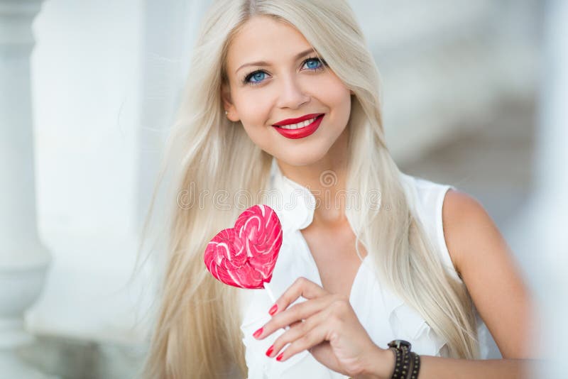 Beautiful blonde with a heart-shaped lollipop